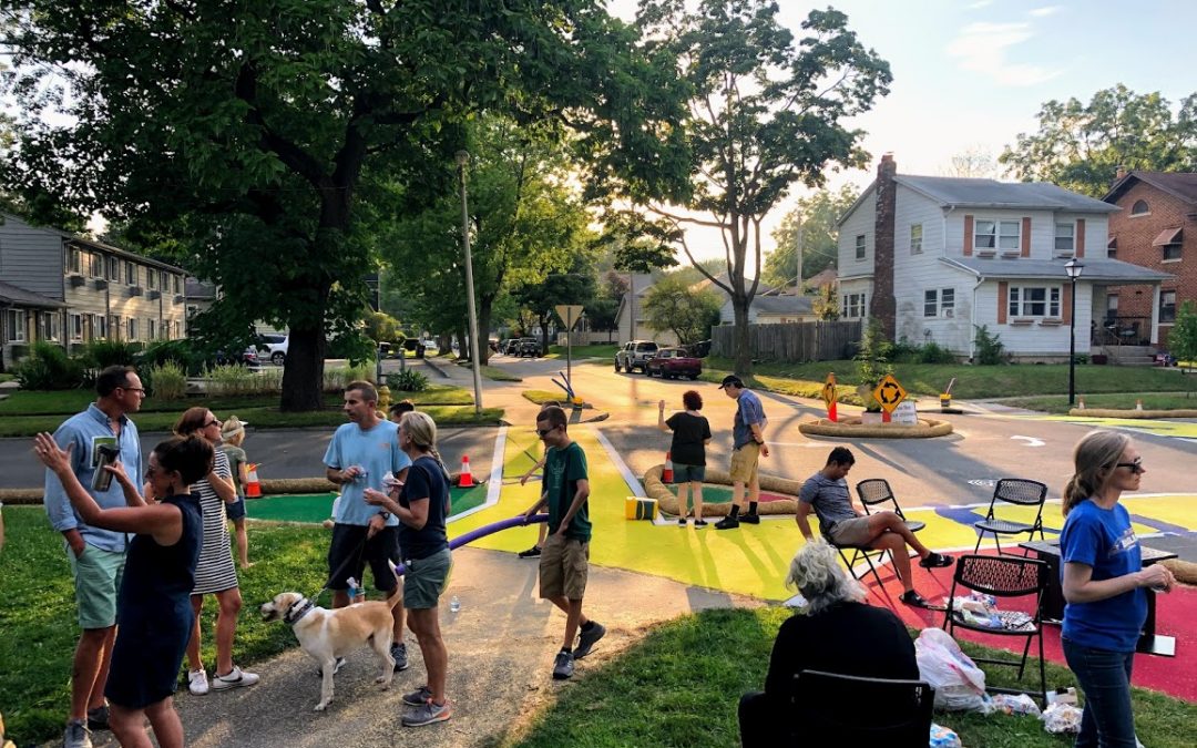 People gathered at an intersection in a neighborhood.