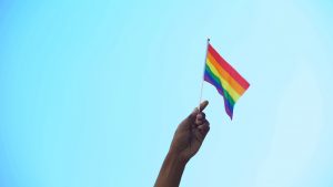 Hand holding rainbow flag