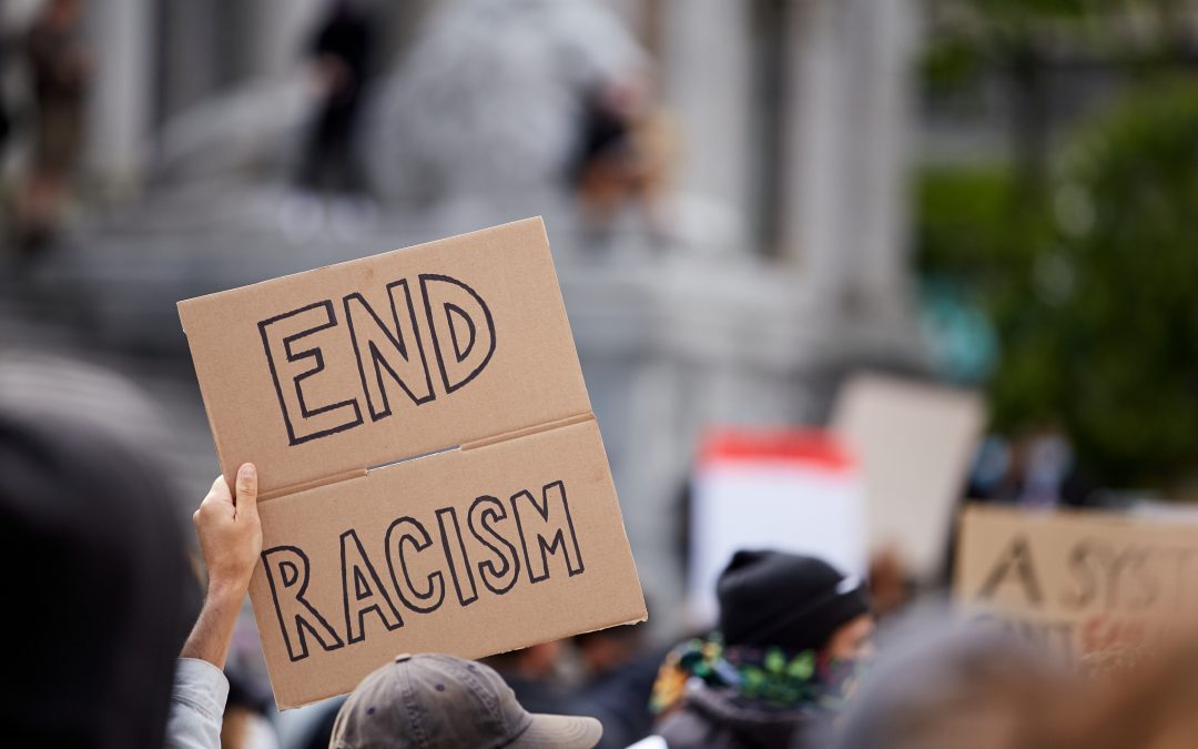 Protester holding sign that says "END RACISM"