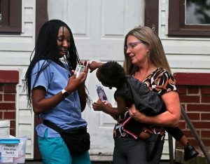 Lakeeta Watts standing by Sherri Ohly, who is holding Watts’ son, Isaiah