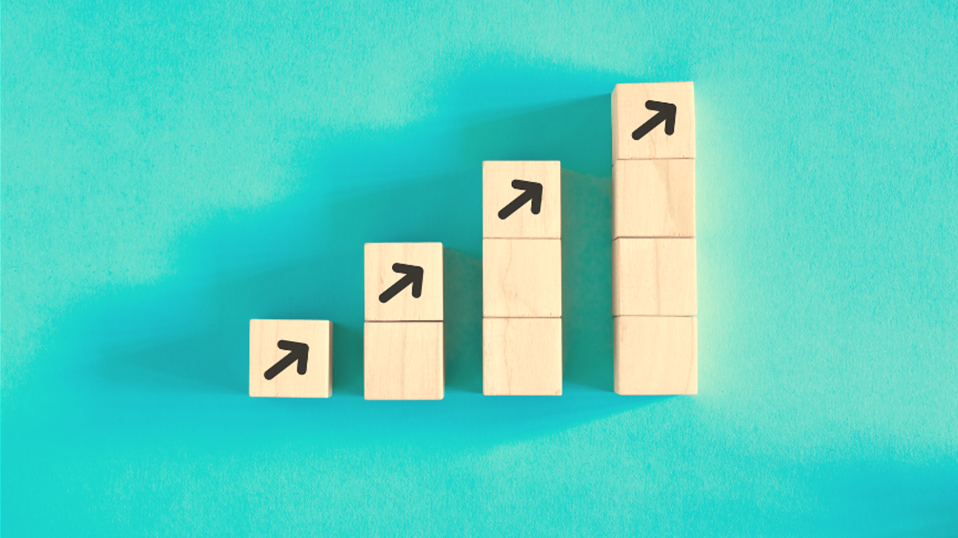 Wooden blocks stacked up, increasing in column length from left to right (starting with one block on the left, ending with four blocks on the right). Each top block has an arrow pointing up.