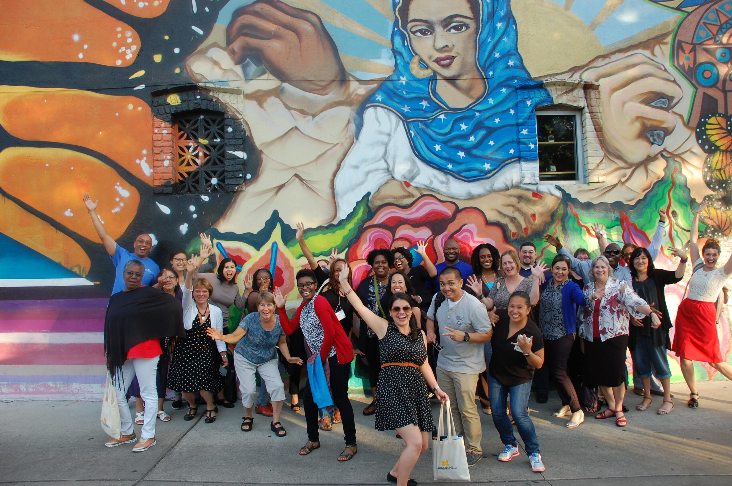 People standing in front of a mural in Detroit